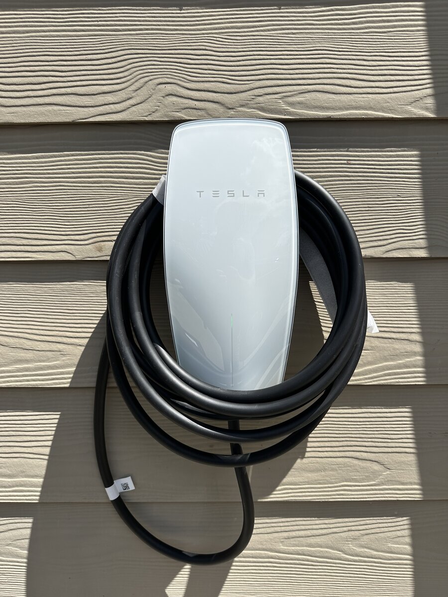Tesla EV charger with conduit running along garage ceiling